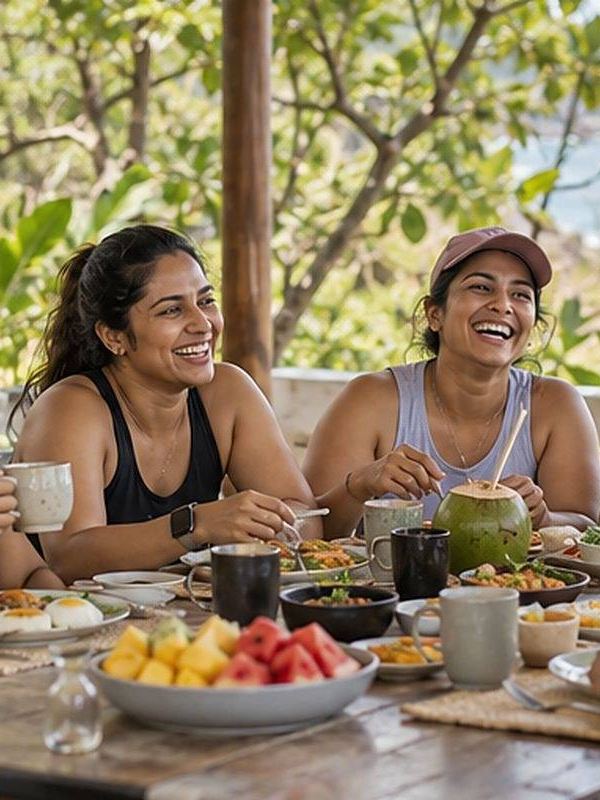 Friends laughing over a long breakfast by the sea